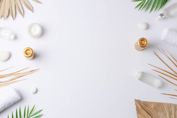 istock Spa treatment with cosmetic bottle, candles and palm leaf on white background. Flat lay, copy space 1355168560