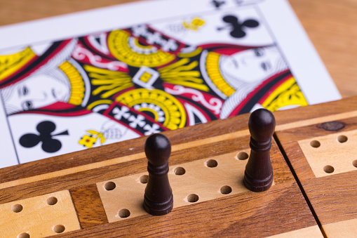 Wooden backgammon pieces stacked on top of each other on the backgammon board with game dice on them