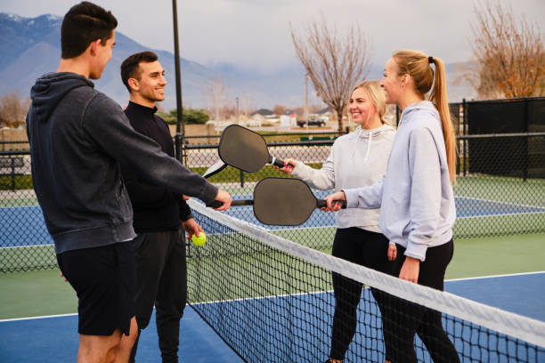 giovani adulti che giocano a pickleball - doubles foto e immagini stock