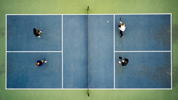 junge erwachsene spielen pickleball - doubles stock-fotos und bilder