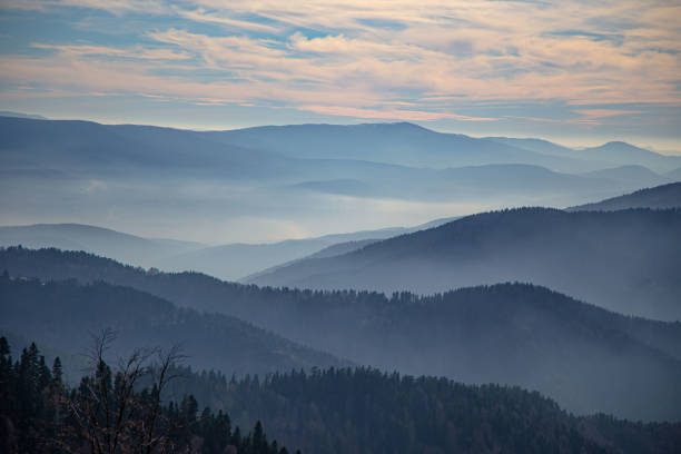 istock Mountains and sky view with clouds and fog 1355175846