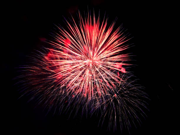 istock Red yellow smoke fireworks at black night sky, black background 1355175986