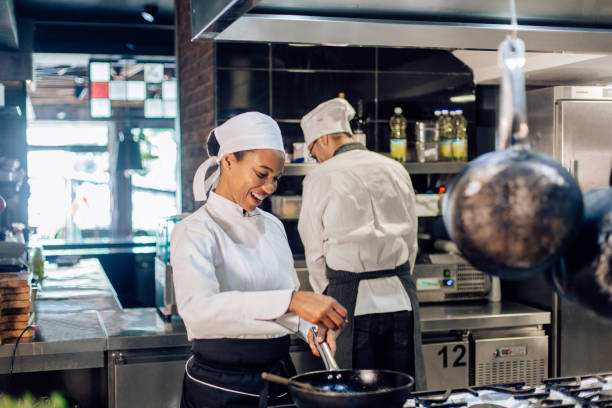 istock African-American cooker working at the restaurant kitchen, together with her chef 1355175990
