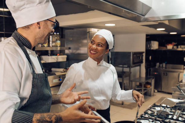 istock Young woman learning from the chef how to cook at the restaurant kitchen 1355176004
