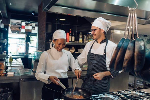 istock Chef and his trainee cooking together 1355176006