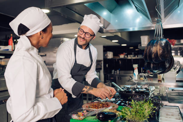 istock African-American woman helping chef at the restaurant kitchen 1355176007