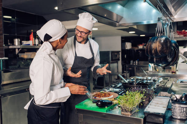 istock African-American woman helping chef at the restaurant kitchen 1355176009