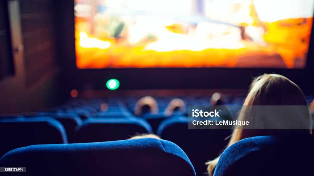 Movie theater during the screening of an animated movie Movie theater during the screening of an animated movie. Movie Theater Stock Photo