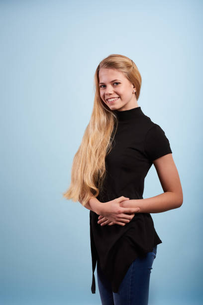 istock Young blond woman standing in front of light blue background 1355177018