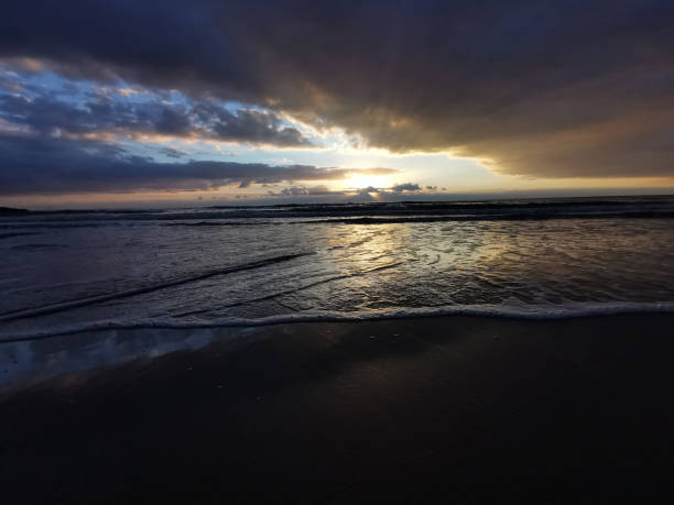 istock sunset over sea with reflection in water, majestic clouds in the sky 1355177175