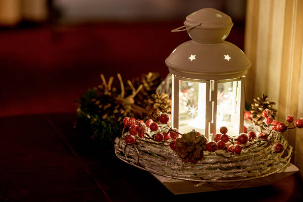 istock Christmas composition bright light glowing lantern, green fir tree branches. 1355188807