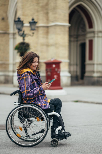 istock Woman with disability using a smartphone while out in the city 1355189710