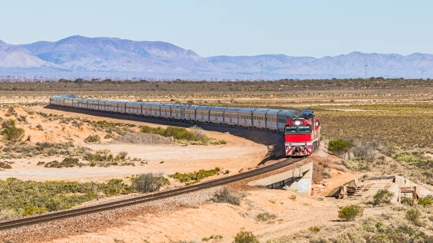 Long distance luxury passenger train with red engine in outback South Australia with Flinders Ranges backdrop Long distance luxury passenger train with bright red engines curving through outback South Australia with Flinders Ranges backdrop. 16x9 format. ID and logos edited from The Ghan.
Heading north across the headwaters of Spencer Gulf enroute to Darwin from Adelaide. The spectacular Flinders Ranges contrast with the arid, desert sand dunes in the foreground. Telephoto view alice springs photos stock pictures, royalty-free photos & images