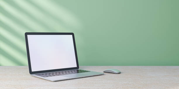 istock 3D rendering object. Laptop computer mouse placed on wood desk and pastel green wall with sun light. 1355196355