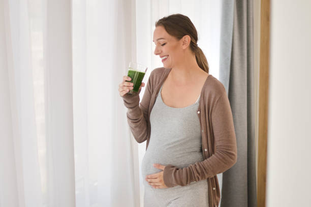 istock Pregnant woman drinking a smoothie 1355200028