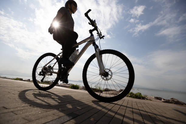 istock Riding bike without holding the handlebar on the sunrise coast path 1355201328