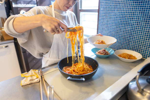 istock Japanese woman serving spaghetti on a plate 1355203410