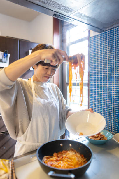 istock Japanese woman serving spaghetti on a plate 1355203468