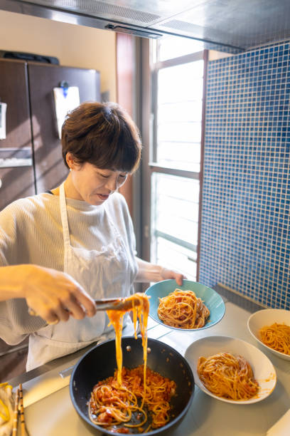 istock Japanese woman serving spaghetti on a plate 1355203547