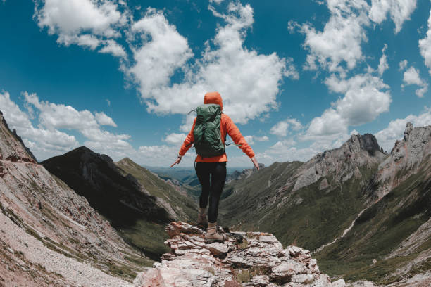 istock Successful woman backpacker hiking on alpine mountains 1355203649