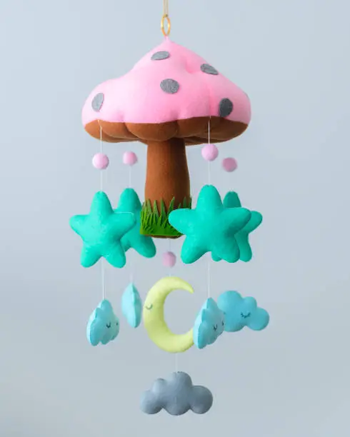 Beautiful Baby Cot mobile, Plushie mushroom with stars, clouds, and the moon hanging from strings. Nursery decor to calm and dream sleep for babies.