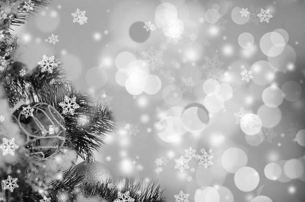 Black and white Christmas background with snowflakes and bokeh.