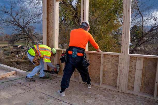 istock Two workers attaching a wall to the sub-floor on a new construction home building site 1355212788