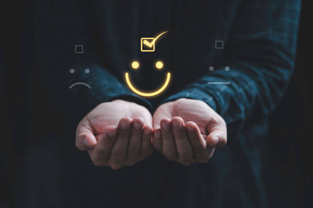 istock Two hands holding and select smiley face icon for client evaluation and customer satisfaction after use product and service concept. 1355212799