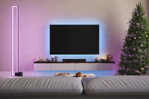 Modern Living Room With Television Set, Christmas Tree And Ornaments At Night With Neon Lights