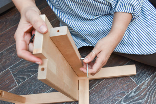 istock woman hands assembling wooden furniture with tools during quarantine isolation. 1355218473