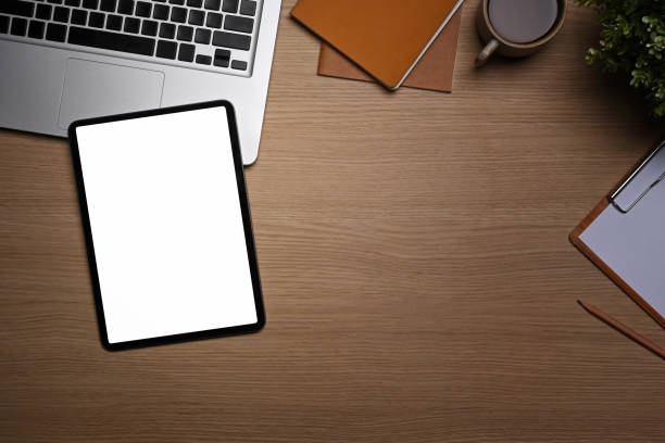istock Top view digital tablet, laptop computer, notebook and house plant on wooden table. 1355219263