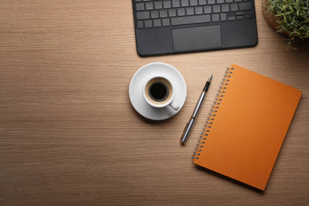istock Flat lay notebook, coffee cup and laptop computer on wooden background. 1355219328