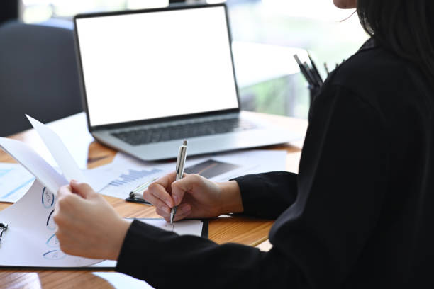 istock Cropped shot businesswoman writing information on document. 1355219371