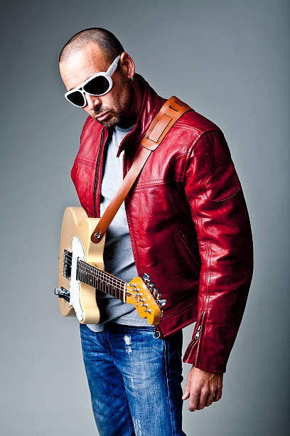 istock Man with electric guitar and glasses in studio 135522317