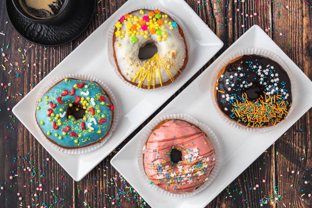istock Delicious donuts decorated with different decorations on wooden table 1355223422