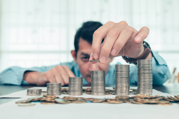Hand putting money coins stack growing, saving money for finance accounting concept. stock photo