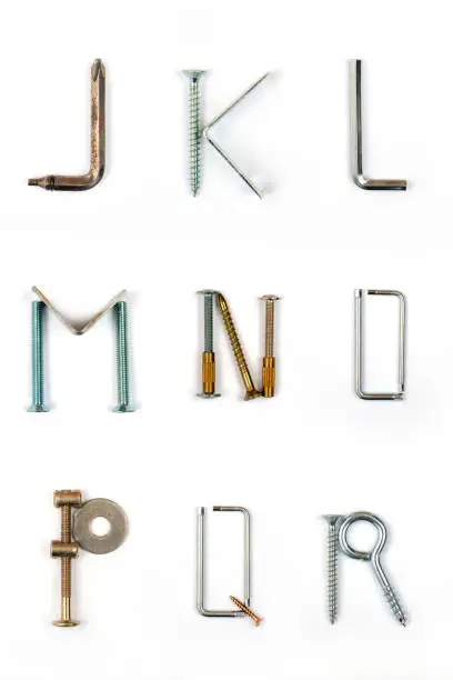 Industrial alphabet. Letters J, K, L, M, N, O, P, Q, R, made of nails and screw. Flat lay, top view.