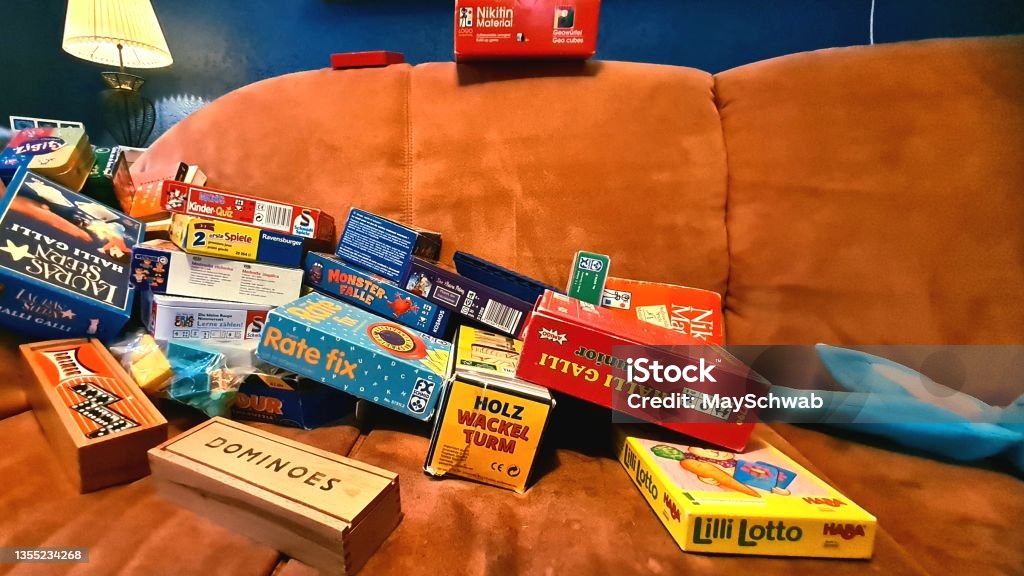 Boardgames Collection Games collection, terracotta sofa in front of blue wall. Board Game Stock Photo