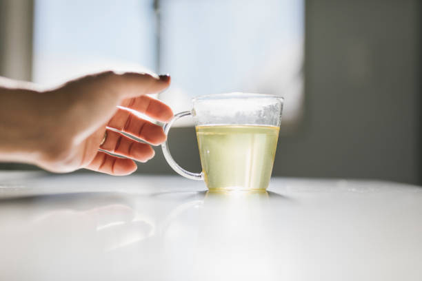 istock Hands of woman touching tea cup gently 1355235091