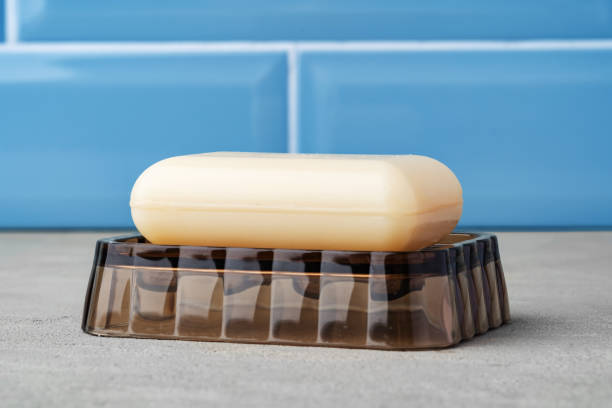 barre de savon blanc sur plat en plastique dans la salle de bain bleue - bar of soap photos et images de collection