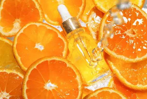 Facial serum in a glass bottle with vitamin C. A cosmetic product in water with a natural ingredient for all ages.
