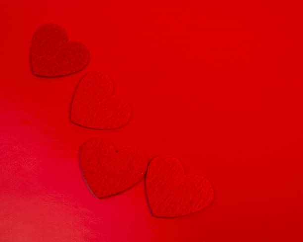 istock Red felt hearts love decor on the red background 1355238500