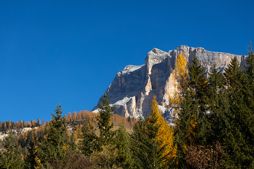 Alta Badia, Italy, 30 October 2021. Fall, the Dolomites are tinged with red, yellow and green. The blue sky frames this enchanted picture.