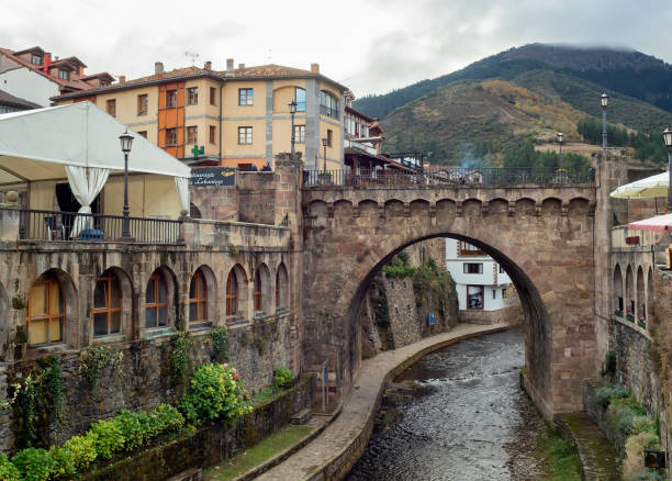 Potes,Cantabria,Spain Potes, Cantabria, Spain, September 20, 2018. View of the bridge, Quiviesa river and medieval buildings in the town of Potes, Santander, Cantabria. spanish flower pots stock pictures, royalty-free photos & images