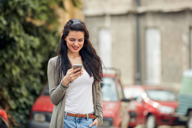 istock Young cute female using smartphone on the street. 1355244729