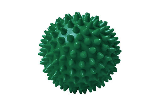 Green plastic spiny massage ball isolated on white. Concept of physiotherapy or fitness. Closeup of a colorful rubber ball for dog teeth on a white color background. Corona virus model.