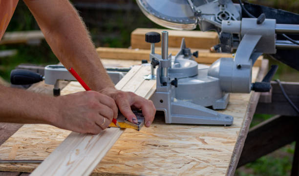 a worker marks the cut size on a wood board a worker marks the size of the cut on a wooden board with a pencil, the photo was taken outside on a sunny summer day miter saw stock pictures, royalty-free photos & images