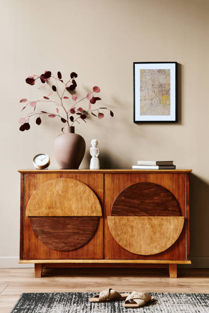istock Stylish interior with design wooden commode, mock up poster frame and elegant personal accessories. Modern living room in classic house. 1355250669