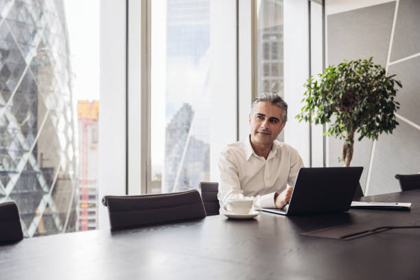 London executive using laptop in modern board room
