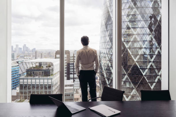 istock Contemplative British businessman looking out window 1355250975